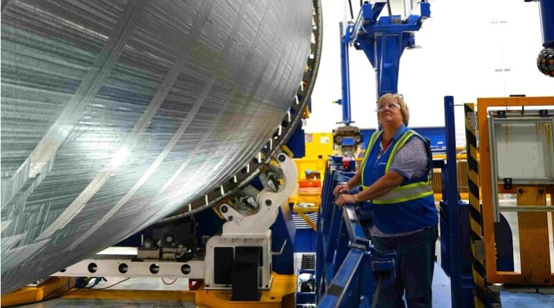 Acima, a Boeing Technical Fellow Karin Anderson verifica o sistema de distribuição de fita de fibra de carbono de uma máquina de colocação de fibra automatizada na Boeing South Carolina. (Boeing | foto de Kaitlin Stansell)